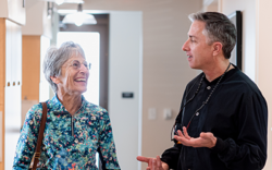 A senior dental patient laughing and talking with her dentist during a visit for a dental exam.