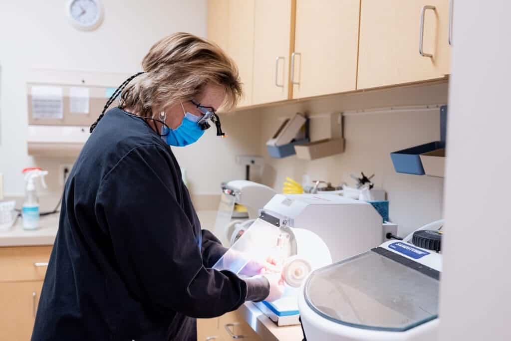 Dental hygienist preparing professional teeth whitening treatment for a patient in clinic